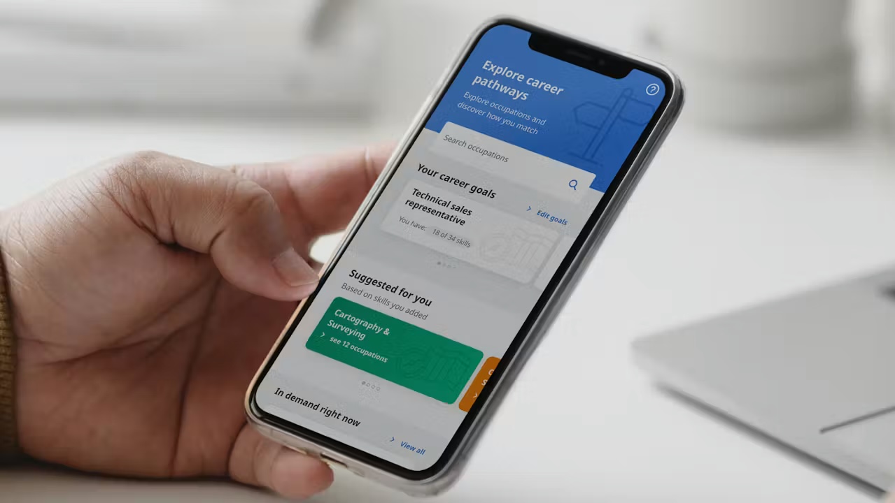 A person holding a phone showing the SkillLab app's career pathway matching screen